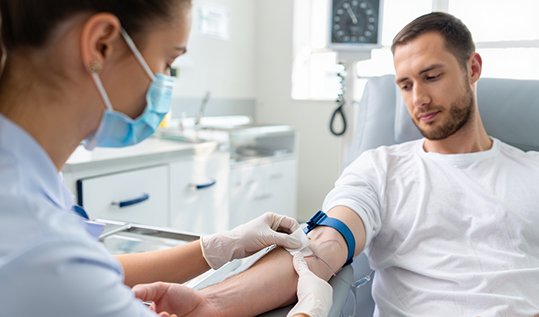 Медицинская сестра берет кровь из вены у пациента для токсикологического анализа