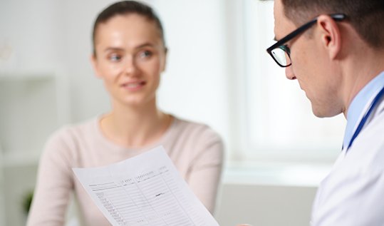 Врач клиники объясняет женщине результаты комплексного анализа крови