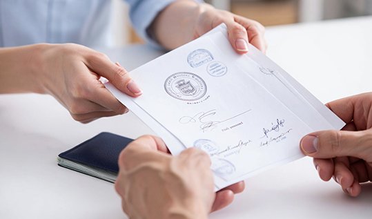 Администратор клиники передает пациенту готовую справку с печатью